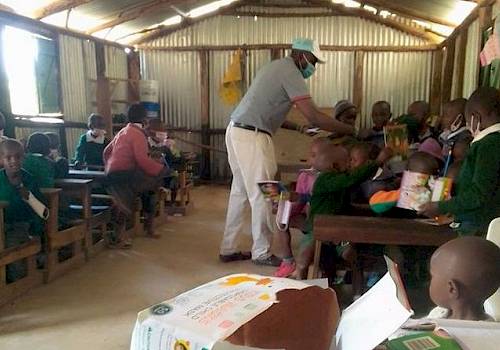 Joseph Nganga handing out donated school books to children