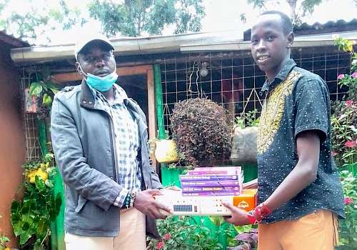 Victor receiving items donated by Vanessa Grant Trust for the school